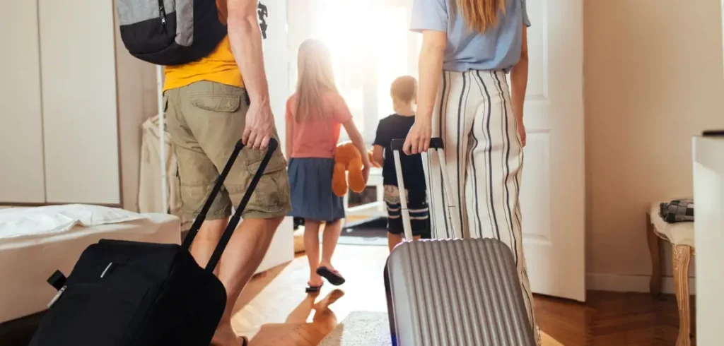 family with luggage leaving their house on vacation.